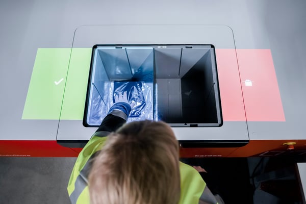 Operator reaching into correct compartment of AutoStore bin indicated by Intuitive Picking Assistant