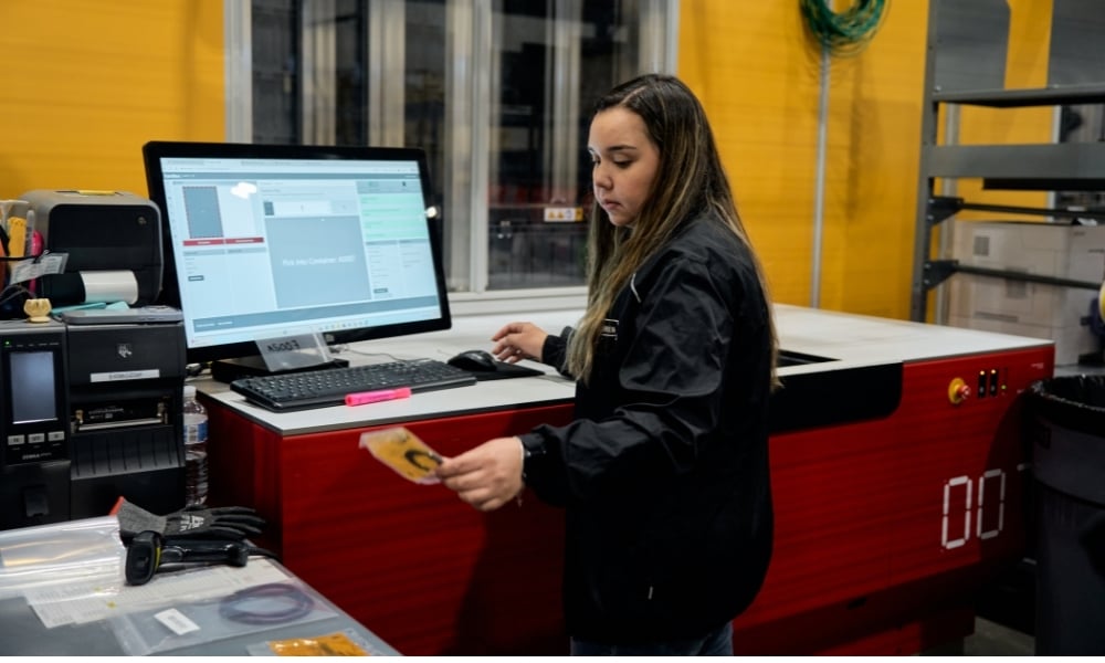 Operator picking rubber gaskets from AutoStore system in warehouse