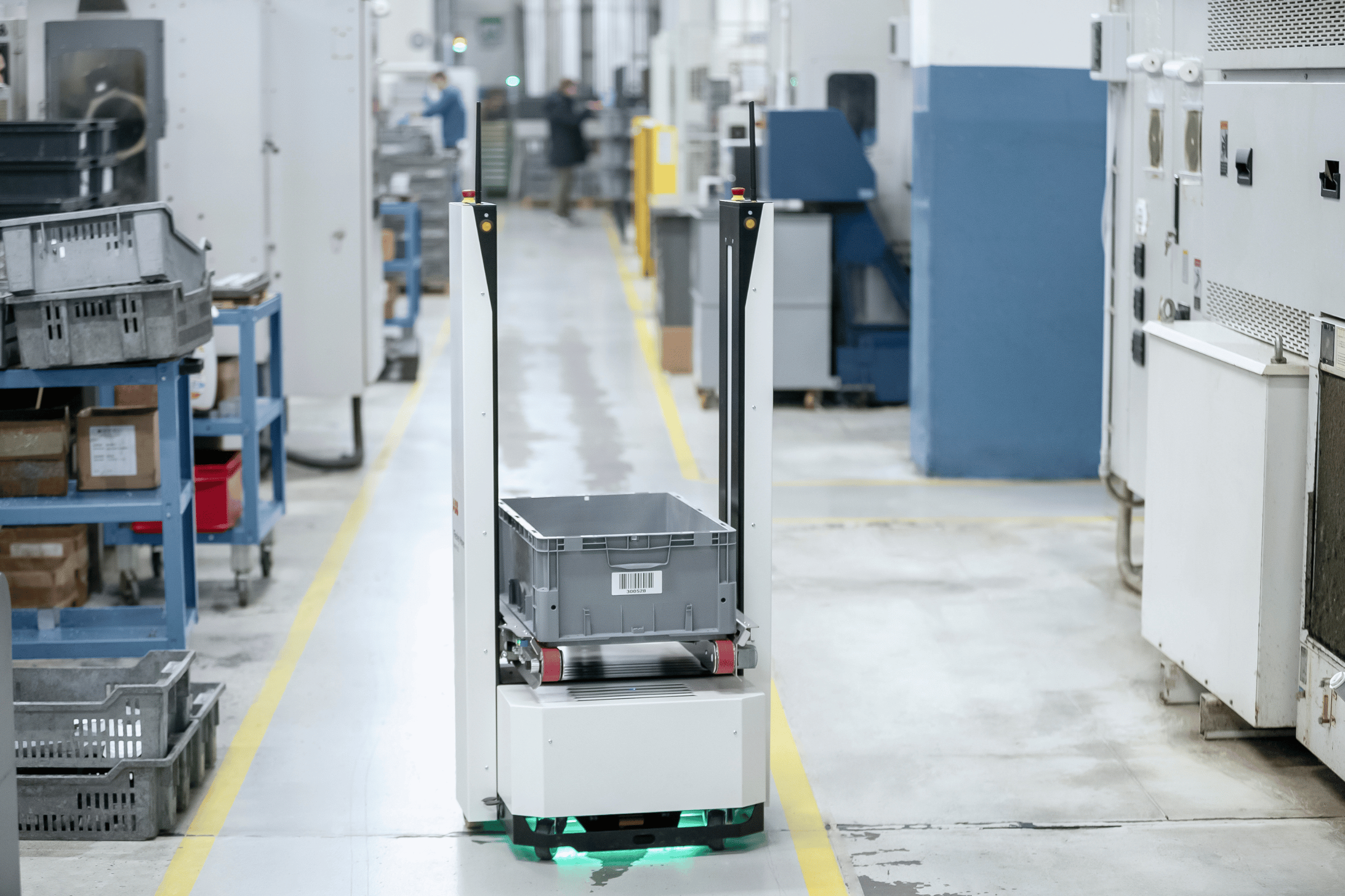 an AMR carries a tote across the warehouse floor